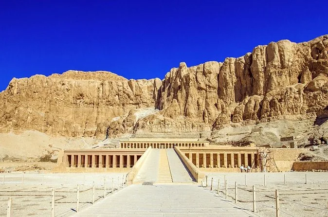 Der Hatschepsut-Tempel mit seiner langen Mittelrampe unterhalb der Felsen unter tiefblauem Himmel