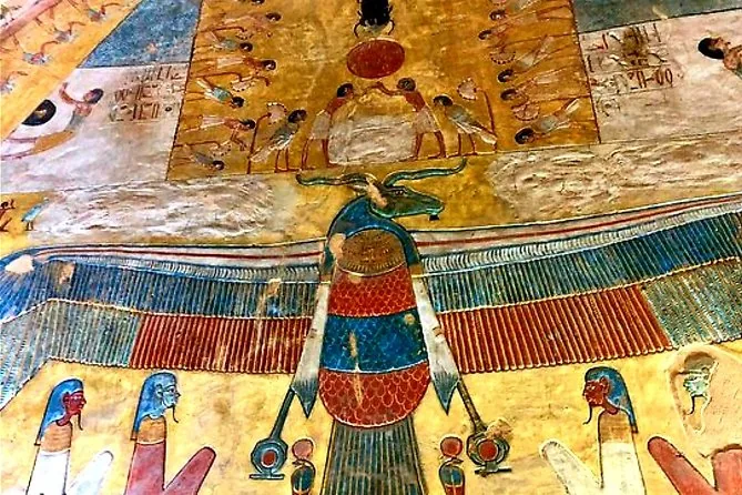 A tomb ceiling painted in yellow and blue with a winged goddess and rows of hieroglyphs